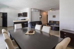 a dining room and living room with a table and chairs at Poolside tranquil apartment in Playa del Carmen in Playa del Carmen