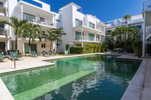 a swimming pool in front of a building at Poolside tranquil apartment in Playa del Carmen in Playa del Carmen
