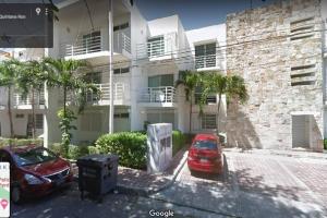 a red car parked in front of a building at Poolside tranquil apartment in Playa del Carmen in Playa del Carmen
