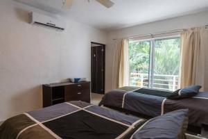 a hotel room with two beds and a window at Poolside tranquil apartment in Playa del Carmen in Playa del Carmen +52 photos