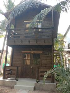 a small wooden house with a large door at Lamarine Morjim Beach cottages in Old Goa