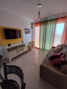 Apple Flat 501 في ناتال: غرفة معيشة مع أريكة وتلفزيون بشاشة مسطحة