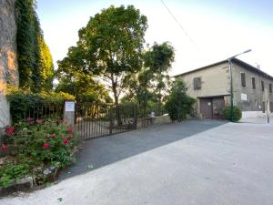 a driveway with a fence and a building with a tree at Le Cocon de Curson chambre d'hôtes in Chanos-Curson