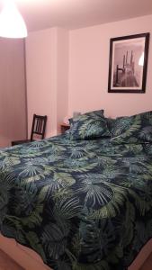ein Schlafzimmer mit einem Bett mit einer grünen Bettdecke in der Unterkunft au bord du lac in Gérardmer