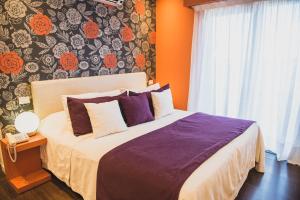 - une chambre avec un lit et un mur orné de fleurs dans l'établissement Los Muelles Boutique Hotel, à Carmelo