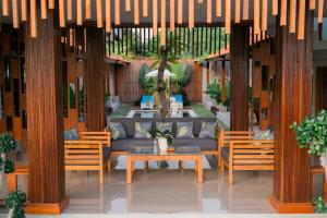 a patio with chairs and a table and a couch at The Ume in Canggu