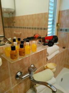 a bathroom with a shelf with bottles of orange liquid at Villa Marija Ulcinj in Ulcinj +52 photos