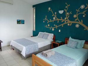 1 dormitorio con 2 camas y un mural en la pared en Casa Del Aire, en Mérida