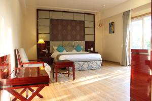 a bedroom with a bed and a table and a chair at 7 Seasons resort & Spa in Jamnagar