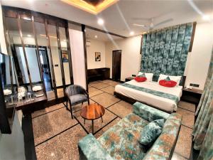 ウダイプールにあるSuvin Residency with Rooftop Swimming Poolのベッドとソファ付きのホテルルーム