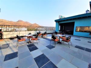 a patio with tables and chairs on a roof at Suvin Residency with Rooftop Swimming Pool in Udaipur