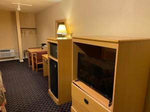 um quarto de hotel com uma televisão de ecrã plano e uma sala de estar em Wildwood Inn em Florence