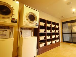 - une buanderie avec un lave-linge et un sèche-linge sur un mur dans l'établissement Hotel Route-Inn Aomori Chuo Inter, à Aomori