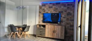 a living room with a table and a tv on a wall at ÁTICO TRIPLEX ISLA VERDE in El Campello