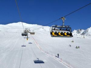 a ski lift with people on a snow covered slope at Suite il sogno di Grebek in Passo del Tonale