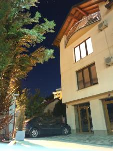un coche aparcado delante de un edificio por la noche en Apartment Imamović, en Vogošća