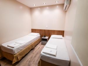 a hospital room with two beds and a mirror at HUB Hotel in Teresina