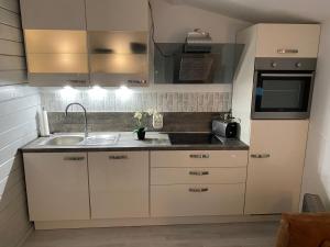 eine Küche mit weißen Schränken und einem Waschbecken in der Unterkunft Holzhaus Leverkusen in Leverkusen