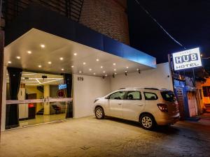 a white car parked in front of a store at HUB Hotel in Teresina