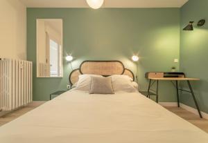 - une chambre avec un grand lit aux murs verts dans l'établissement apparthotel-gare-chambery, à Chambéry