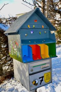 una casa de juguete con techo azul en la nieve en La Ruche, en Tramelan