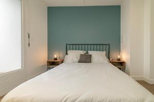 a bedroom with a large white bed with two side tables at apparthotel-gare-chambery in Chambéry