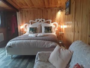 a bedroom with a large white bed with wooden walls at A La Belle Epoque in Valdeblore