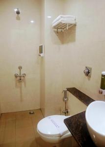 a bathroom with a toilet and a sink at Hotel Laxmi Cityside in Mangalore