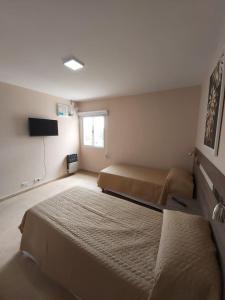 ein Schlafzimmer mit 2 Betten und einem TV in der Unterkunft By Muni Apartamentos Premium in Tanti