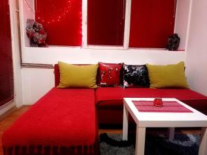 a living room with a red couch and a table at Jednosoban stan centar in Pirot