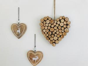 two heart shaped wooden ornaments with a pile of logs at Wohlfühlappartement Kreischberg in Sankt Georgen ob Murau