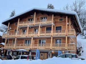 a large wooden apartment building with a balcony at Les Amborzales in Le Grand-Bornand