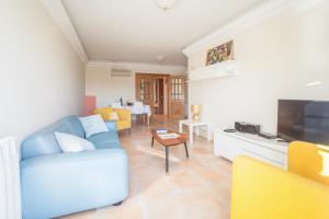 a living room with a blue couch and a tv at Rio Gilao in Tavira