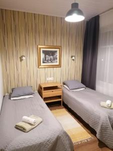 a bedroom with two beds and a picture on the wall at Guesthouse Carl Schmidt in Põltsamaa