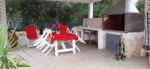 a patio with a table and chairs and a fireplace at Villa paradiso in Ostuni