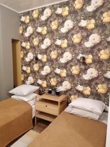 珀爾察馬的住宿－卡爾施密特旅館，一间卧室设有两张床,墙上有鲜花
