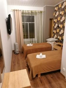 um quarto de hotel com duas camas e uma janela em Guesthouse Carl Schmidt em Põltsamaa