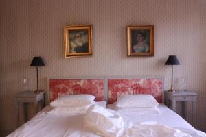 a bedroom with a bed with two pictures on the wall at Runnvikens Pensionat in Tystberga