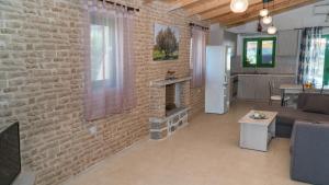 a living room with a brick wall and a couch at Villa Elia in Lambiní