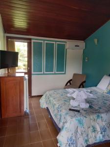 a bedroom with a bed with a teddy bear on it at Hotel Jardim Tropical in Barcarena