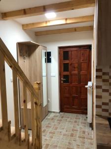 a hallway with a wooden door and a staircase at Apartmani Sredojevic in Kaludjerske Bare