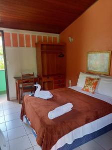 a bedroom with a bed with two white towels on it at Hotel Jardim Tropical in Barcarena