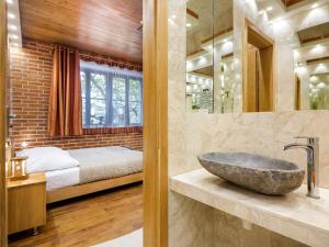 Krowoderska Apartments في كراكوف: حمام مع حوض حجري وسرير