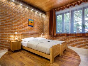 a bedroom with a brick wall and a bed in a room at Krowoderska Apartments in Krakow