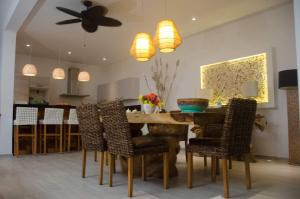 een keuken en eetkamer met een tafel en stoelen bij JADE DUPLEX in Nosy Be