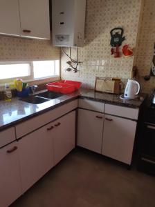 a small kitchen with white cabinets and a sink at Bubuhouse estadía mínima dos noches in Rosario