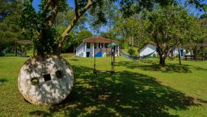 um parque infantil com uma árvore e um baloiço em Hotel Fazenda Pedra Grande em Viscode de Mauá