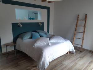 um quarto com uma cama branca e uma cabeceira azul em Les Ronzières em Saint-Paul-dʼUzore