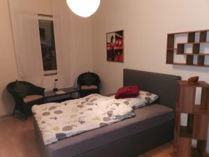a bedroom with a bed and two chairs at Cityzimmer in Nettetal