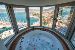 a bath tub in a room with windows at Casa Margot Hotel - Adults Only in Fethiye